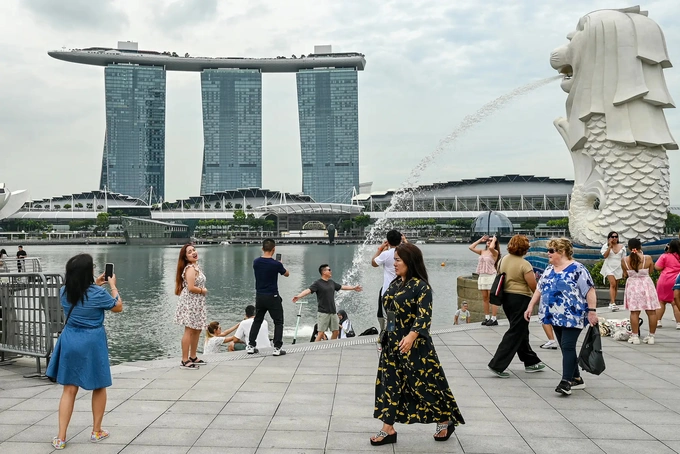People gather next to the Merlion statue in front of the Marina Bay Sands resort in Singapore on Dec. 2, 2024. Photo by AFP