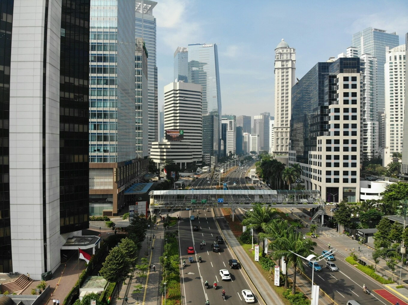 High-angle view of a multi-lane road with traffic and a pedestrian bridge in Jakarta, Indonesia. Photo by Unsplash