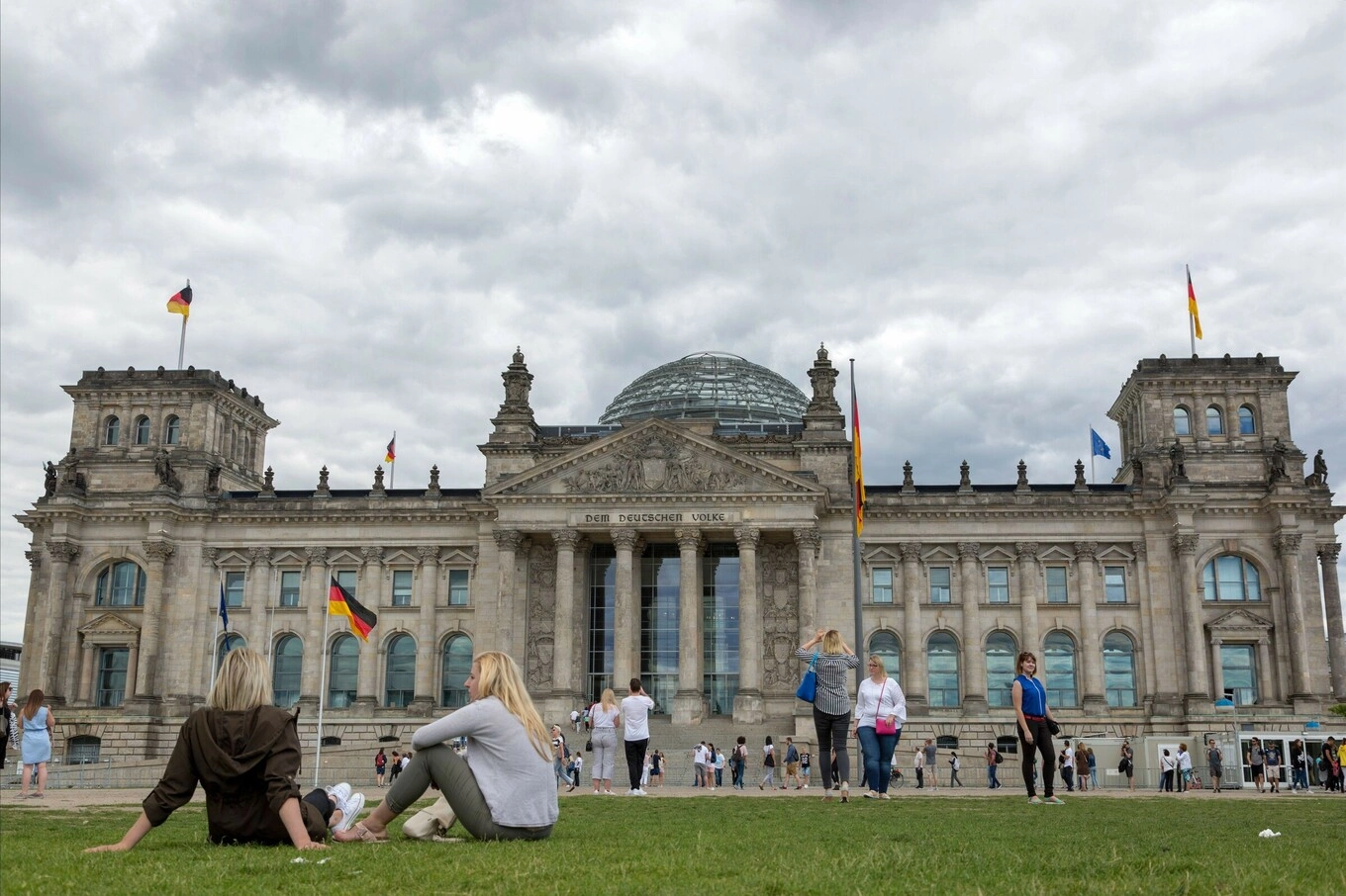 Visitors are seen outside the historic Reichstag Building in Berlin, Germany. Photo by Pexels