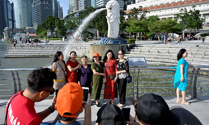 Tourists pose for photographs at Merlion Park in Singapore January 27, 2023. Photo by Reuters