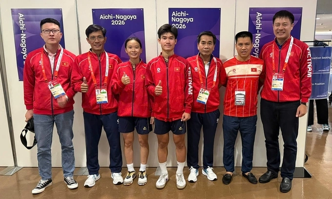 Teqball players Trinh Gia Nghi (third from left), Nguyen Hoang Minh Tan (fourth from left) and their coaches pose for a photo after winning a bronze medal at the 20th ASIAD. Photo by Tam Ninh