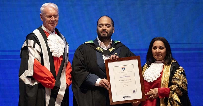 Anant Ambani (center) is presented the Professor of Practice certificate at Newcastle University. Photo from the universitys website