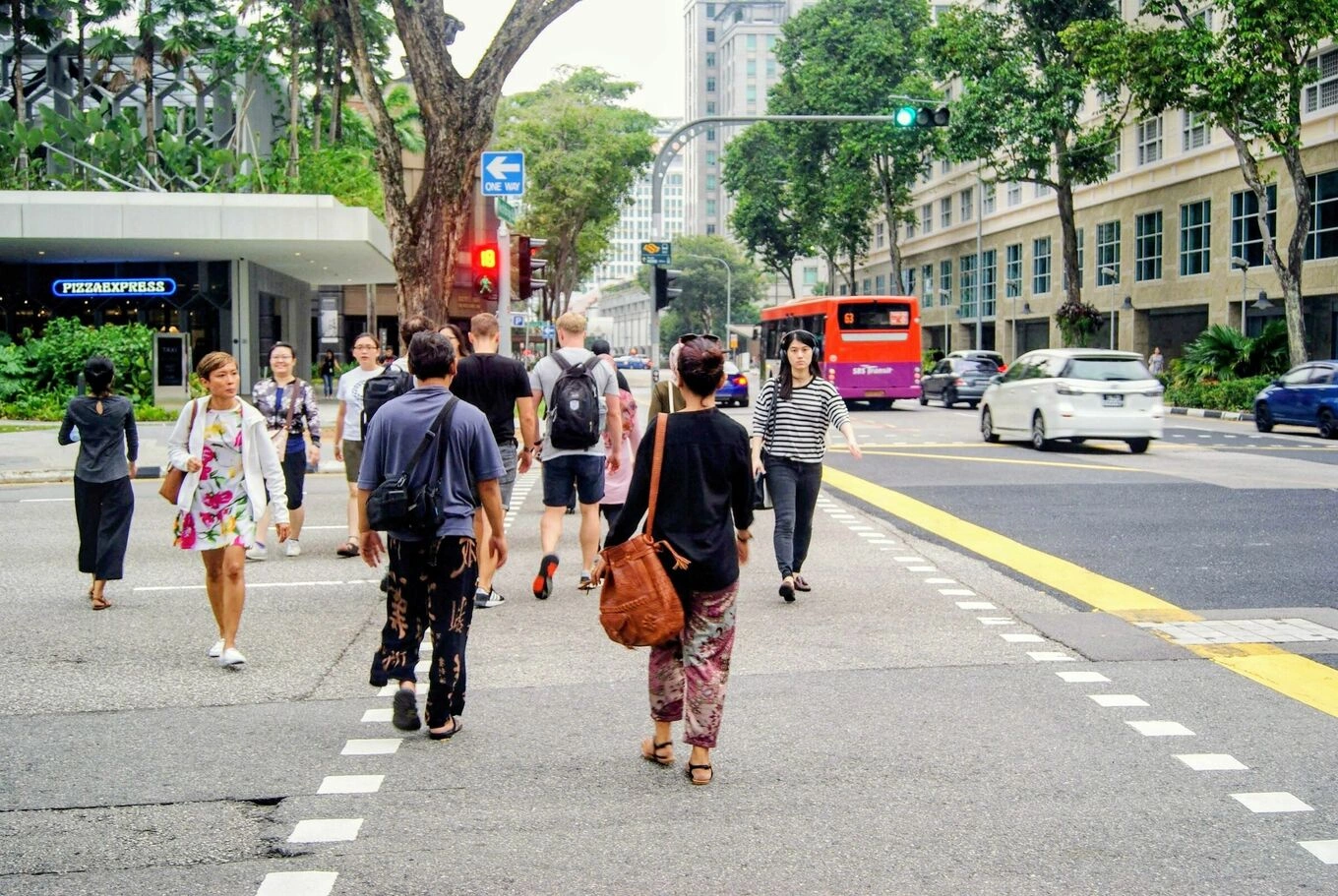 People crossing a busy intersection in Singapore. Photo by Pexels