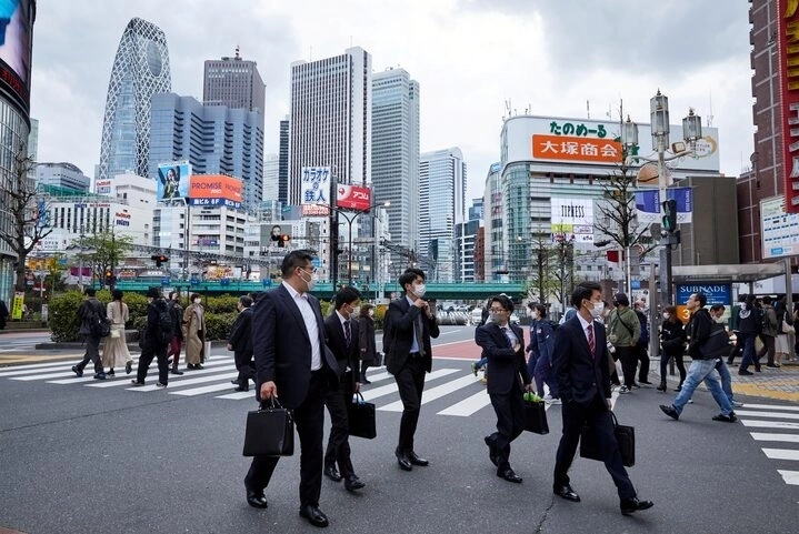 Passersby wearing protective masks during the COVID-19 pandemic walk on the street at Shinjuku district in Tokyo, Japan April 6, 2021. Picture taken April 6, 2021. Photo by Reuters