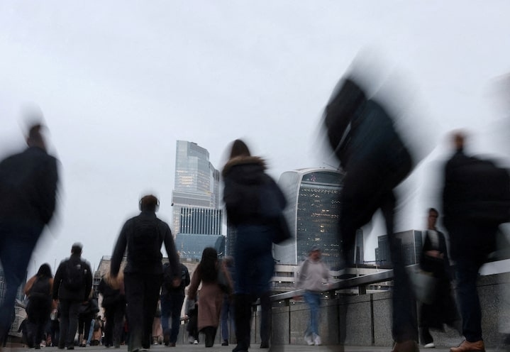 Workers cross London Bridge during the morning rush-hour with skyscrapers of the City of London financial district seen behind, in London, Britain, December 16, 2025. Photo by Reuters