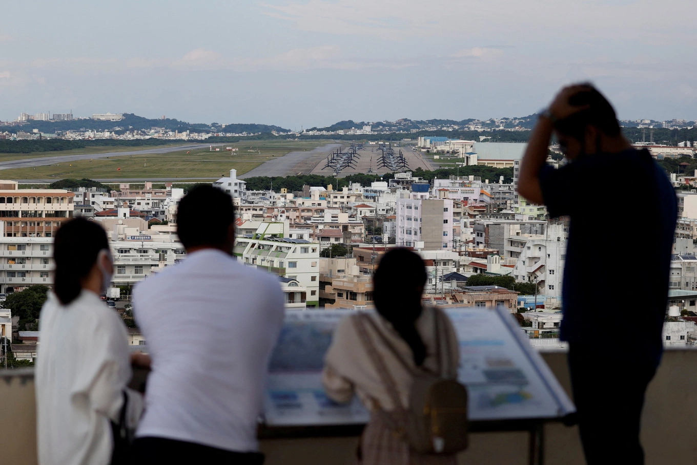 People look at the U.S. Marine Corps Futenma Air Station in Ginowan on the southern island of Okinawa, Okinawa prefecture, Japan, October 24, 2021. Photo by Reuters