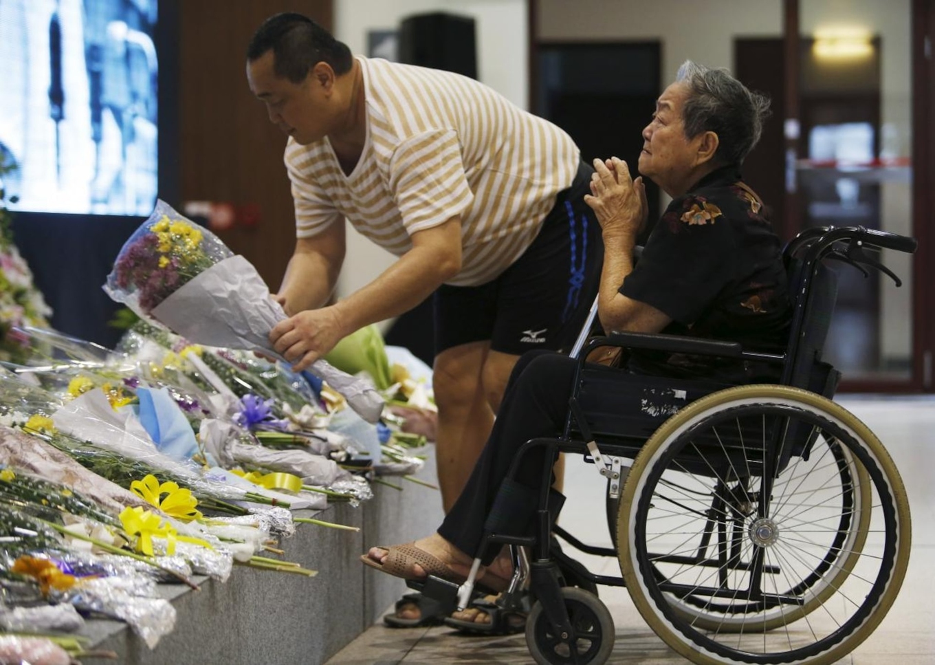 A woman in a wheelchair pays respects to the late former prime minister Lee Kuan Yew at a memorial site in Singapore March 23, 2015. Photo by Reuters