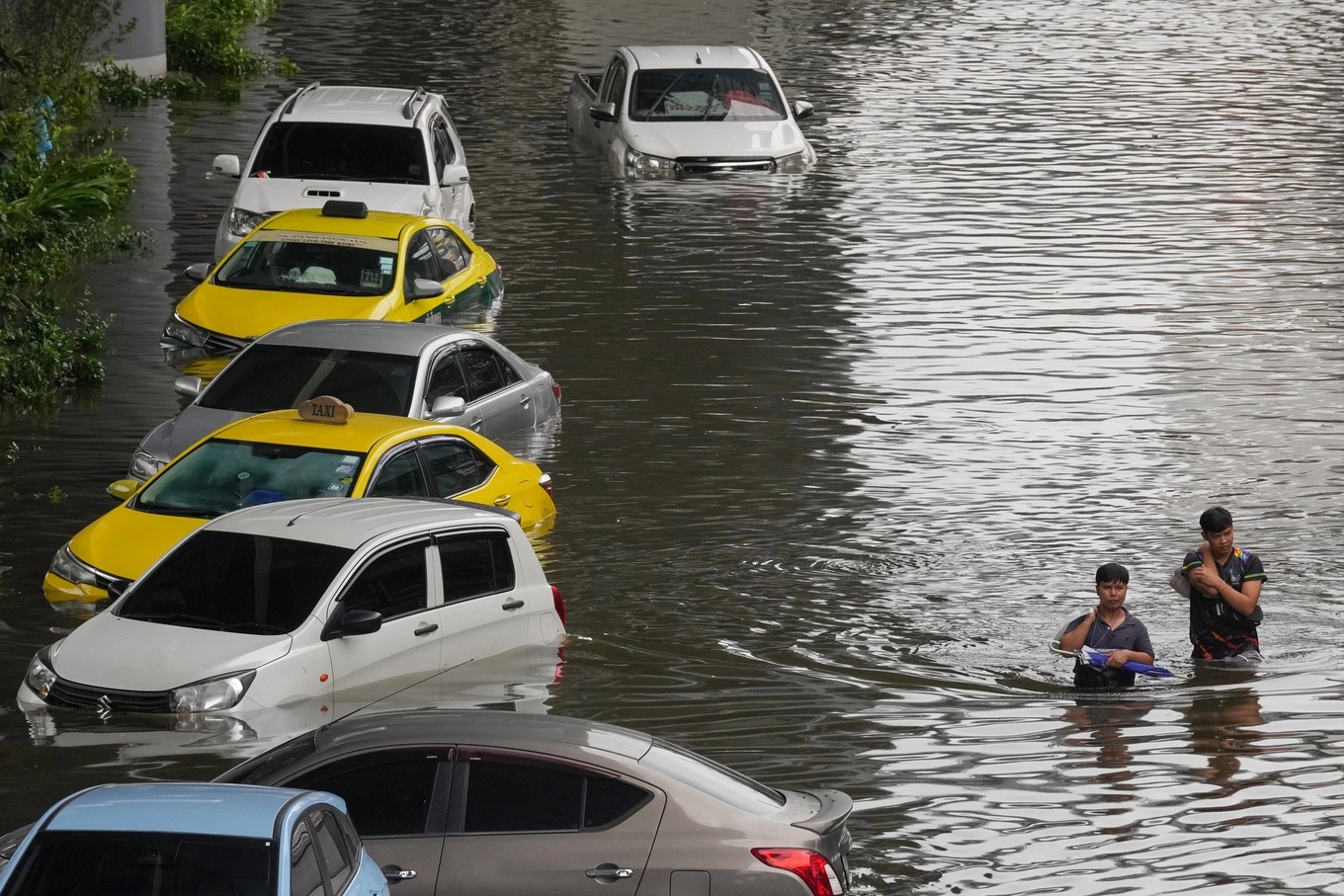 People wade through a flooded street after heavy rain in Bangkok, Thailand, Sunday, Sept. 27, 2026. Photo by AP