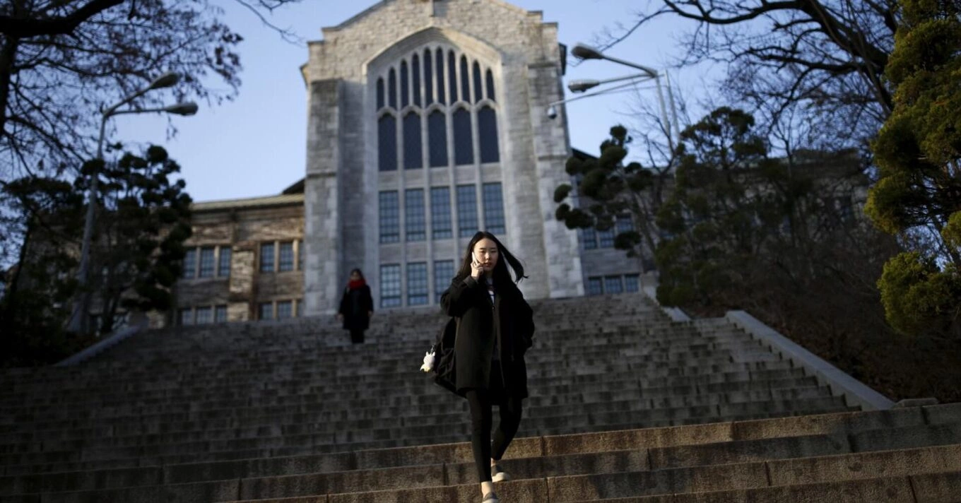A university student talks on the phone as she leaves at Ewha Womans University in Seoul, South Korea, November 30, 2015. Picture taken on November 30, 2015. Photo by Reuters