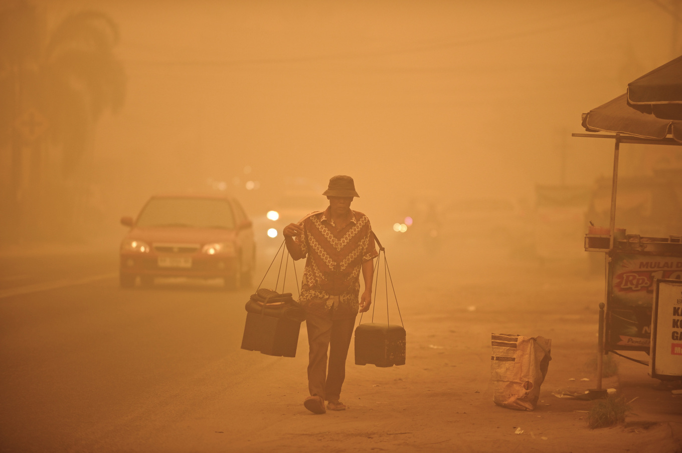 A street vendor walks amid thick haze from wildfires in Palangkaraya, Central Kalimantan, Indonesia, Saturday, Oct. 24, 2026. Photo by AP