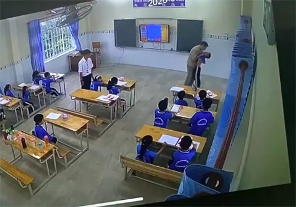 The teacher grabs a pupil by the neck and takes the child out of the classroom on Sept. 22. Photo cut from video